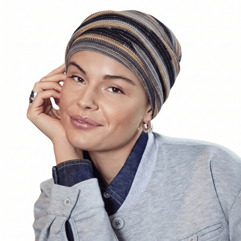 Femme souriante portant le turban Zoya motif Black Autumn Stripes avec plis doux, vue de face