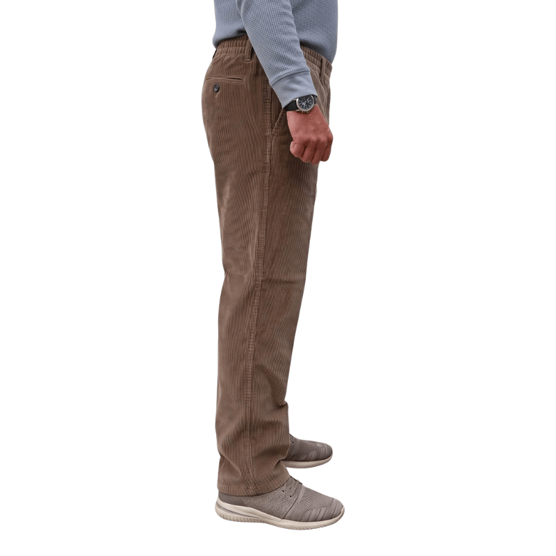 Profil latéral d'un pantalon en velours côtelé marron avec taille élastique et poche avant, porté par une personne