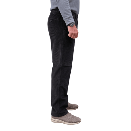 Pantalon en velours côtelé noir confortable avec taille élastique et poches latérales, vu de côté sur une personne