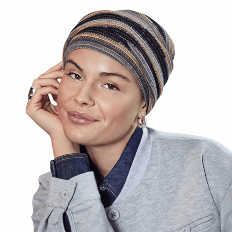 Femme souriante portant le turban Zoya motif Black Autumn Stripes avec plis doux, vue de face