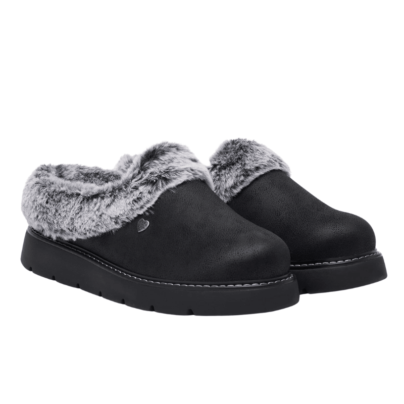 Une paire de chaussons Skechers noirs pour femme avec fausse fourrure grise et aspect daim, vue avant oblique