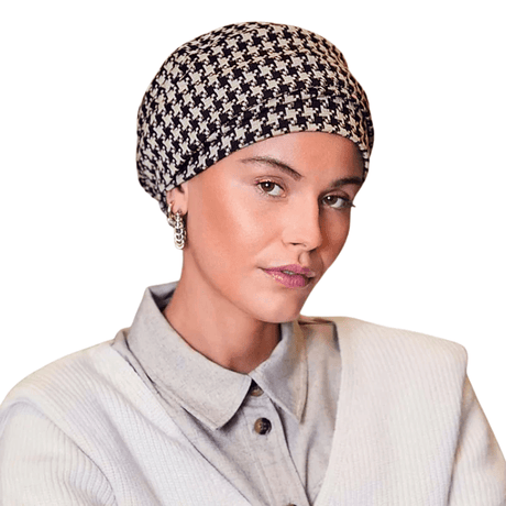Turban Lea à motif pied-de-poule noir et beige, porté de face par une femme, avec un volume élégant