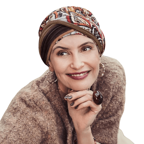 Femme souriante portant le turban Shakti Tribal Feathers imprimé plumes aux couleurs d'automne