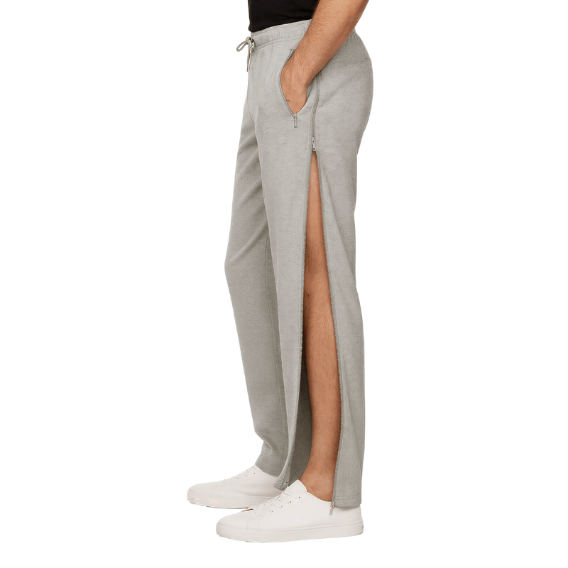 Pantalon de jogging gris avec fermeture éclair latérale ouverte montrant la jambe, vu de côté sur une personne