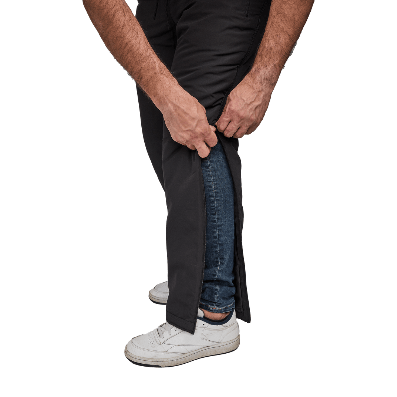 Gros plan de mains ouvrant un pantalon thermique Dobsom sur le côté par-dessus un jean