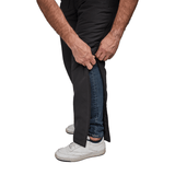 Gros plan de mains ouvrant un pantalon thermique Dobsom sur le côté par-dessus un jean