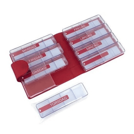 Étui rouge en similicuir ouvert avec sept piluliers transparents et une boîte séparée avec jours et heures
